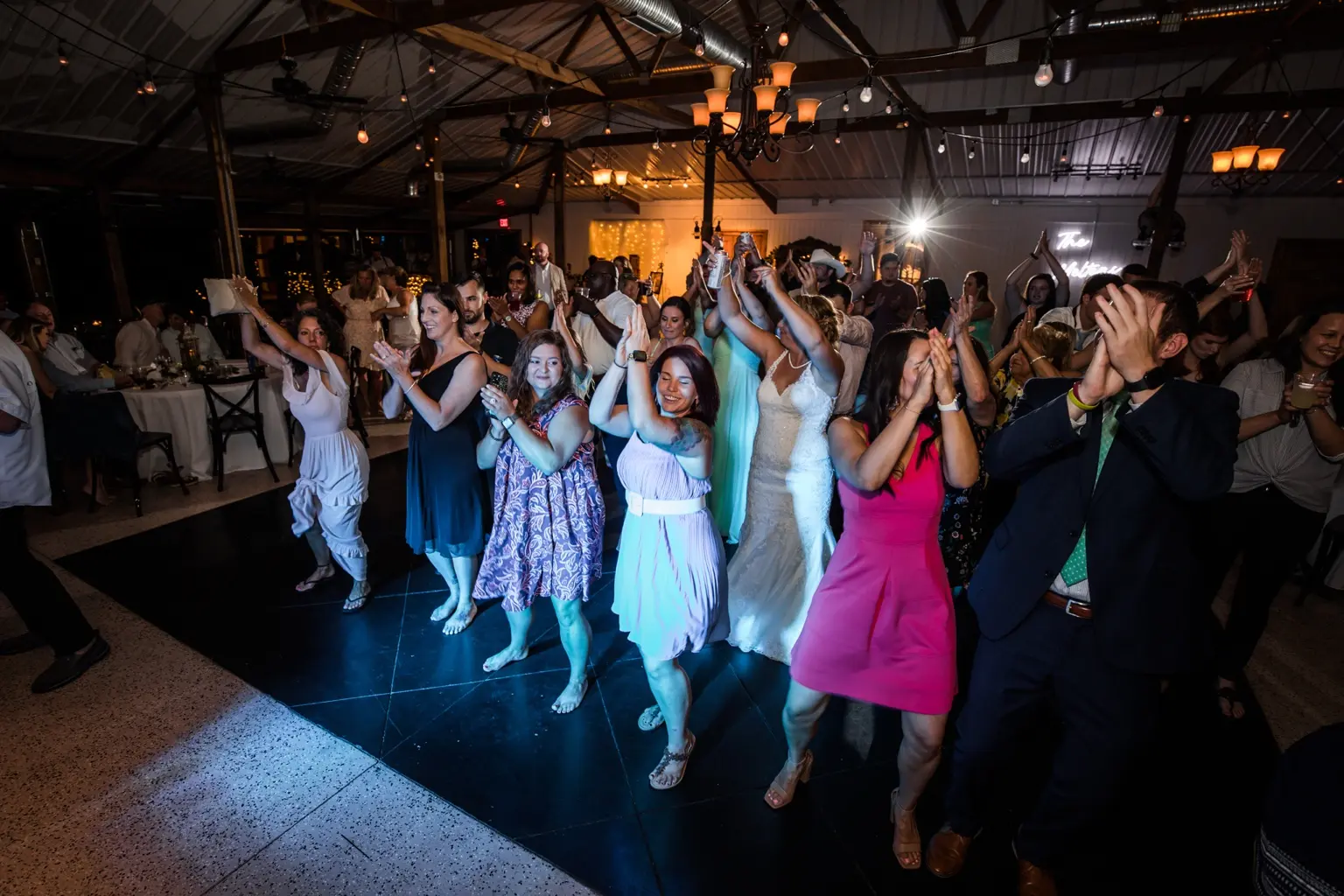 Wedding guests and the bride celebrating together on a full dance floor